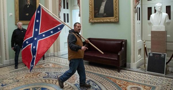 Man seen carrying Confederate flag through Capitol during riot arrested, along with his son