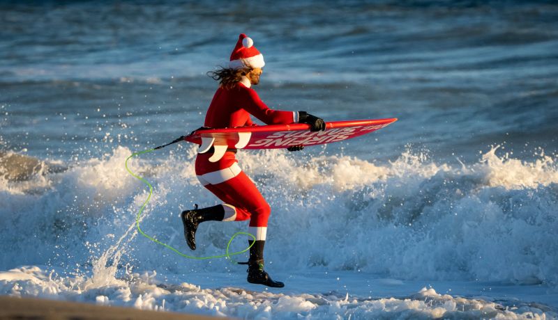 Ace News Today - ‘Surfing Santas’ brave the freezing temps and hit the waves in the Sunshine State